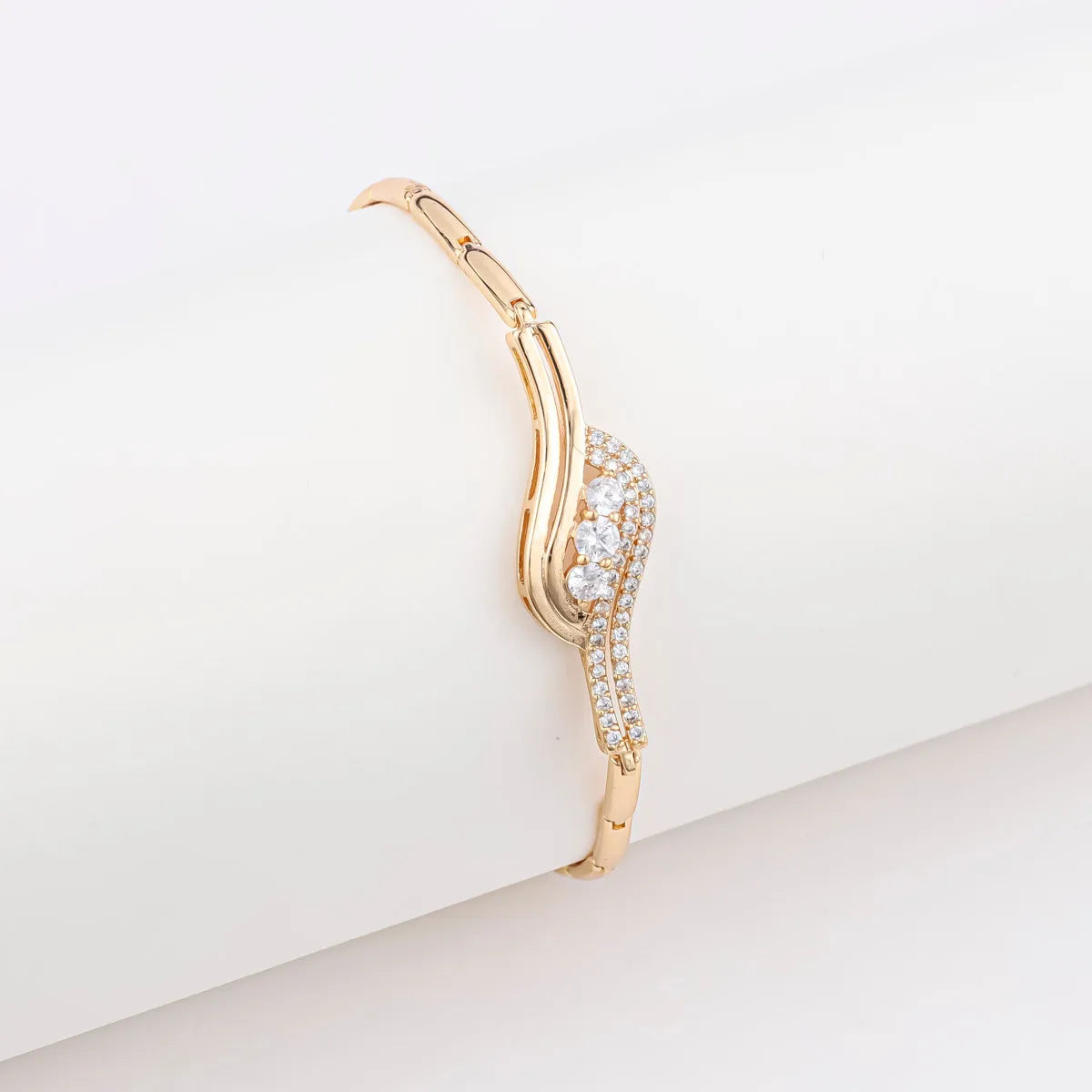 18K gold-plated butterfly clover brass bracelet with zircon stone on plain background