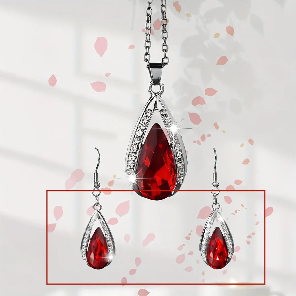 Black and red teardrop glass pendant necklace and matching earrings set on a grey background
