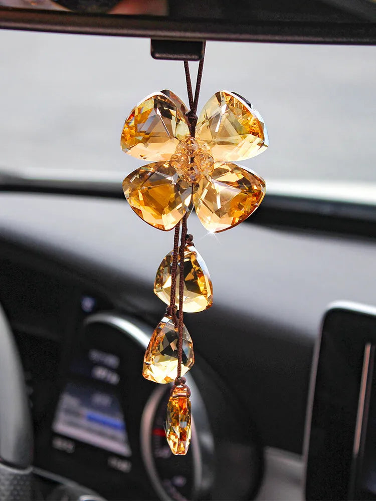 Crystal four leaf grass car pendant hanging, shown in different colour options including transparent and champagne.