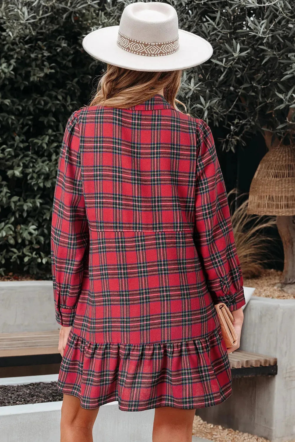 Red and black plaid mini dress with a shirt collar, long sleeves, half-button front, and a ruffled hem.