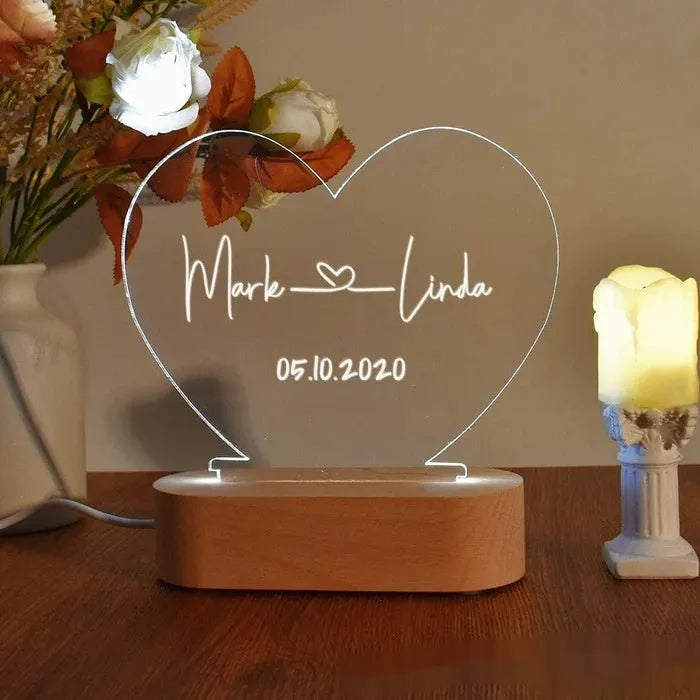 Custom engraved acrylic night light with names and date, illuminated by an LED base.