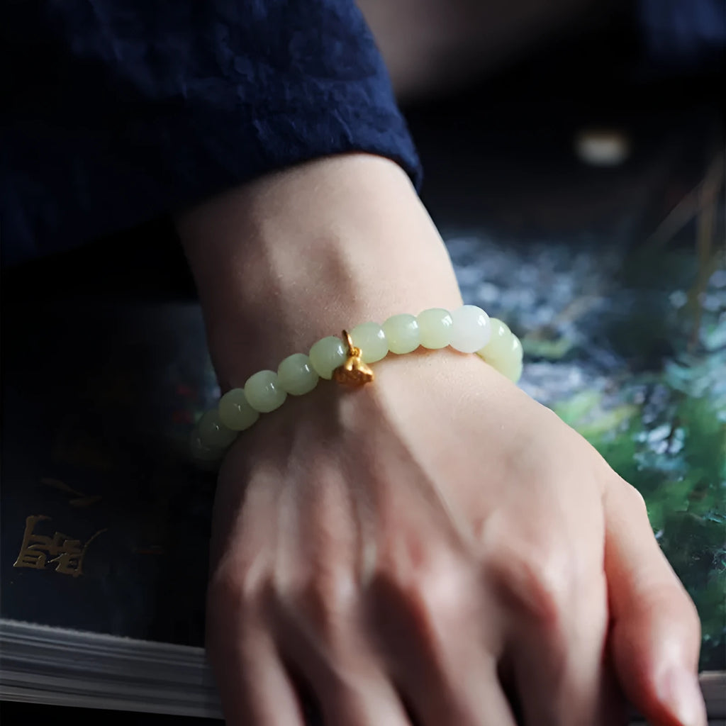 Green Hetian jade bracelet with vintage ethnic style beads on a string.