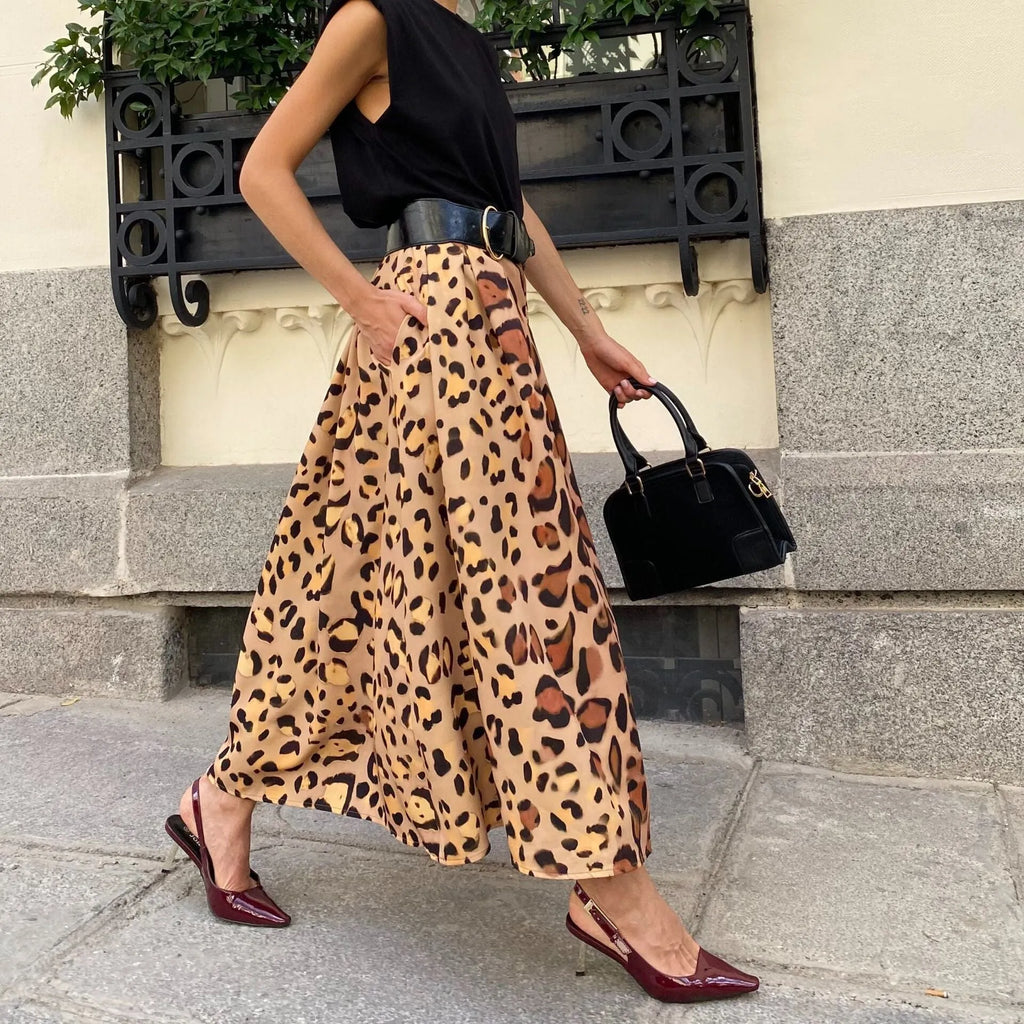 Brown leopard print women's long A-line skirt with a wide flowing hem, shown on a hanger.