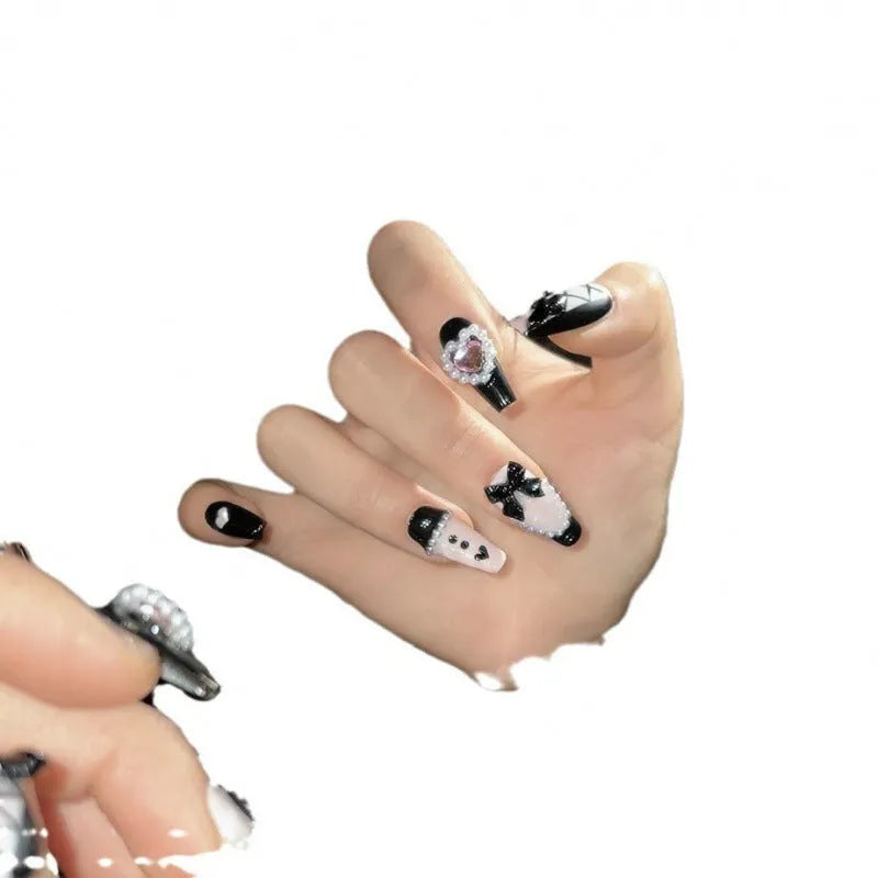 Black pink heart-shaped false nails with hand-painted bow design, Cat's Eye style, in mid-length profile.