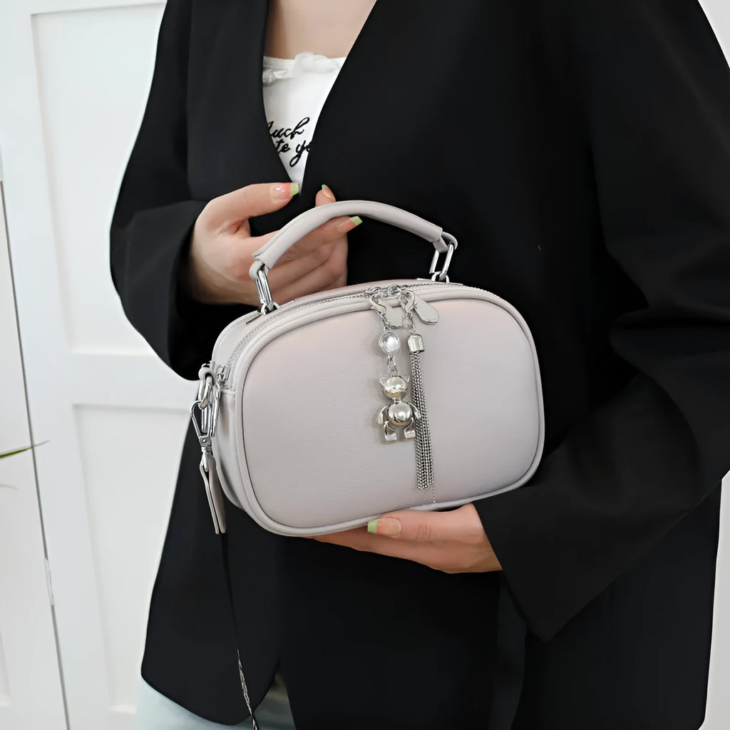 Women's small square bag with stitching detail showing oval shape and double shoulder straps