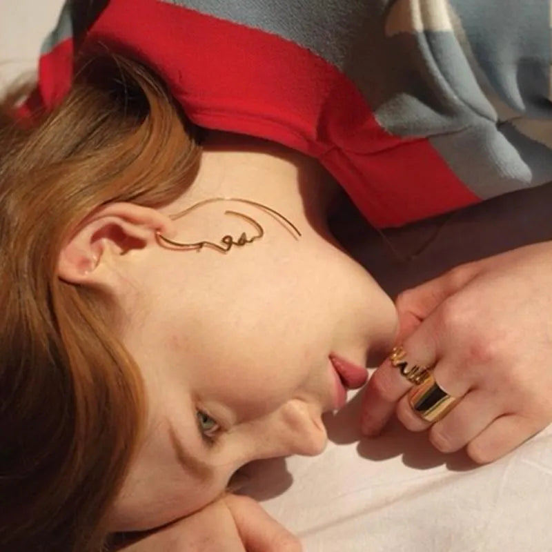 Creative abstract face contour earrings in gold and silver metal finishes, 75 by 35mm