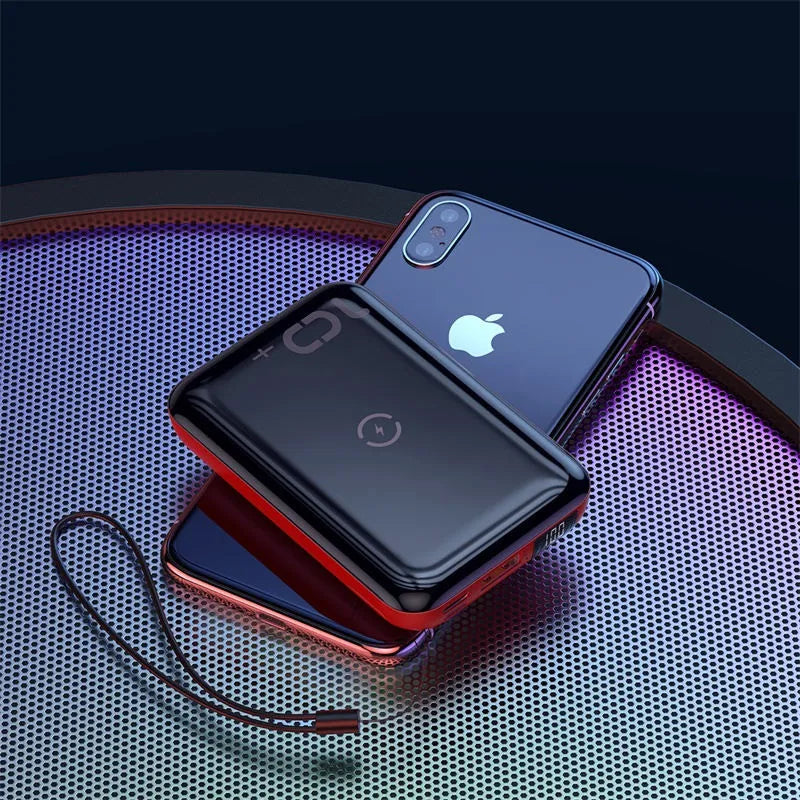 Small square black portable power bank with wireless charging surface and digital LED display.