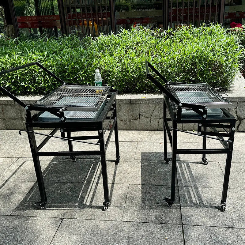 Foldable charcoal BBQ stove with a detachable grill, set up in an outdoor garden.