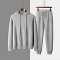 Men's light grey cashmere hooded sweatshirt and matching trousers set laid flat.