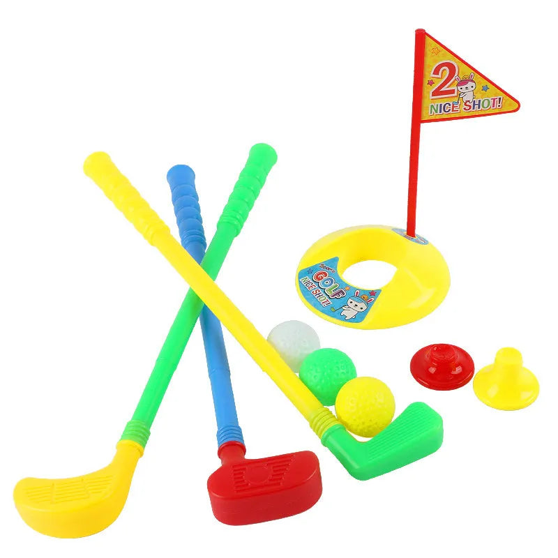 Children's golf set with three clubs, three golf balls, a hole, a flag, and two tees on grass