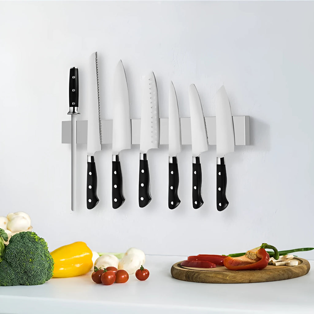 Stainless steel wall-mounted magnetic knife storage rack on a kitchen wall.