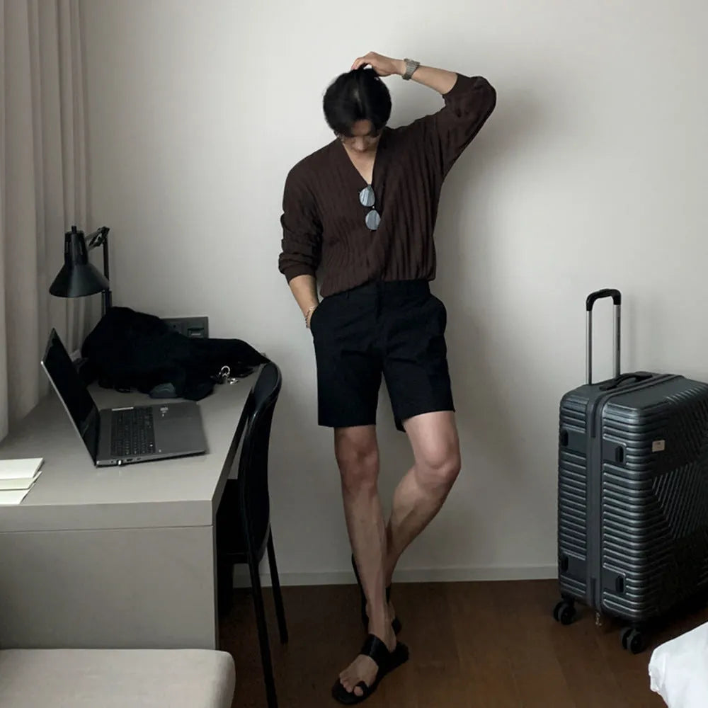 Men's straight-leg polyester shorts in solid black colour showing loose casual fit