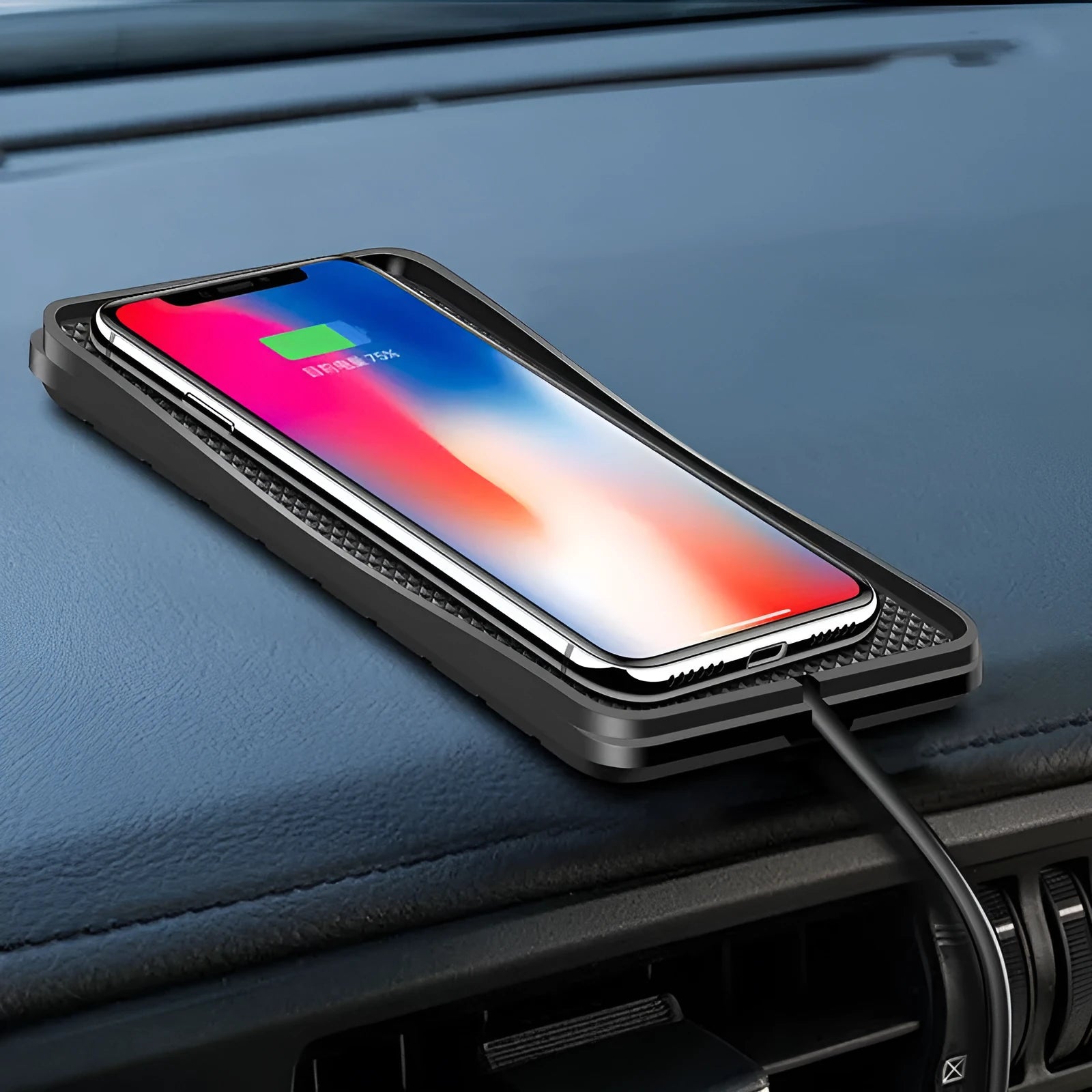 Black universal wireless car charger mount on a car air vent, charging a smartphone.