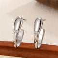 Simple square metal earrings in two styles on a clean background