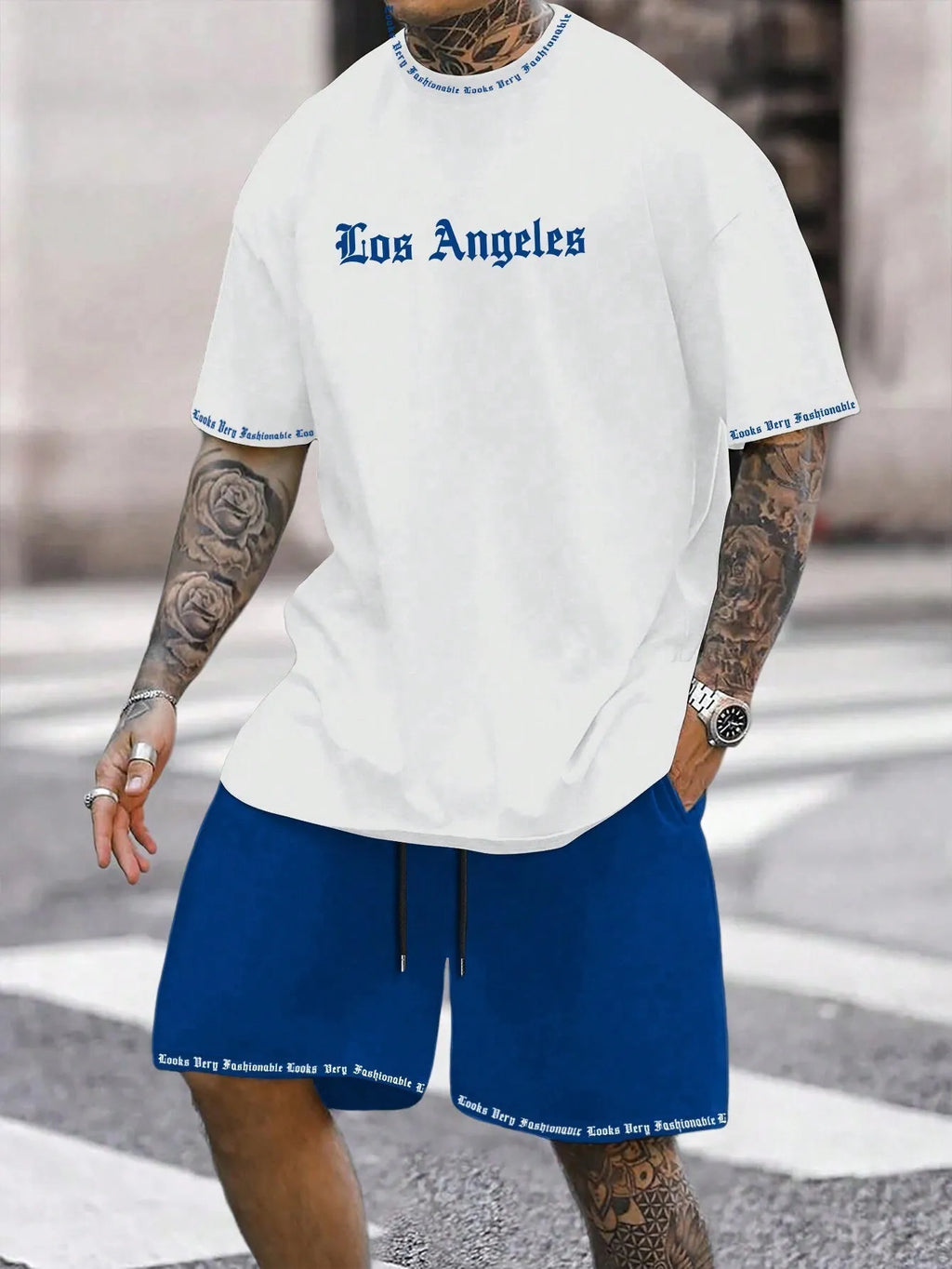 Man wearing a blue short-sleeved top and matching shorts from a sports style suit set.