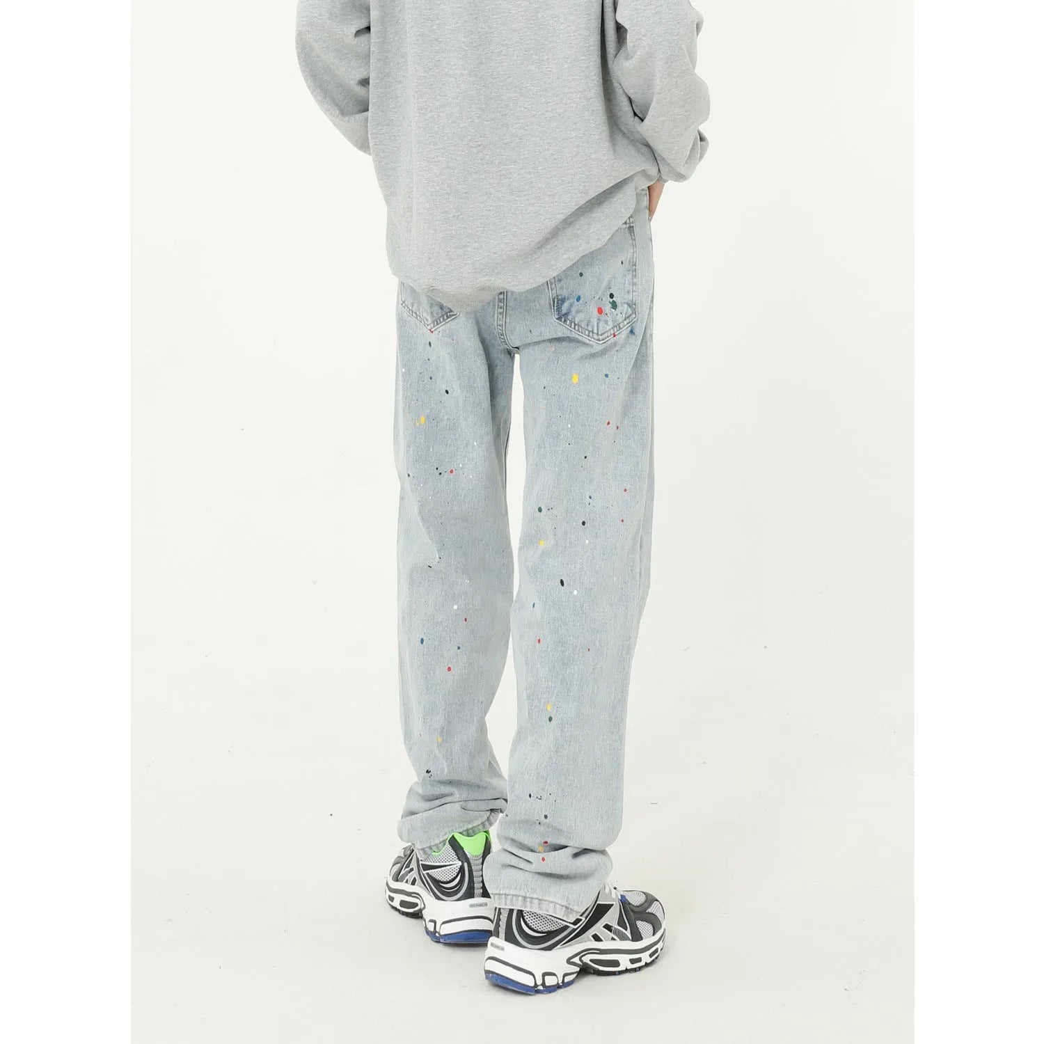 Light blue straight loose jeans with paint splash and washed finish, mid-waist zip fly, laid flat on neutral background