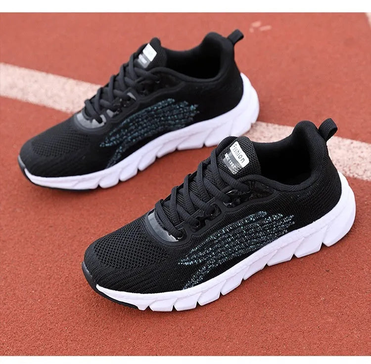 Women's black and white low-top running sneakers with cross strap design and MD soles