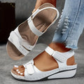 Women's beige thick-bottom strap sandals showing the Velcro fastener and round toe design.