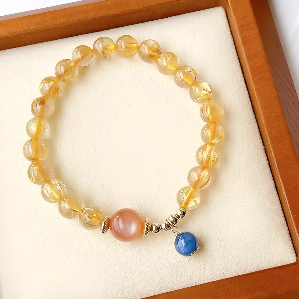 Gold rutilated quartz sunstone crystal bracelet with diamond-cut beads on wrist