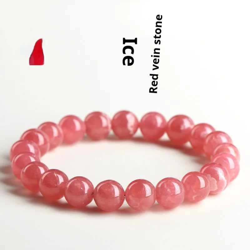 Close-up of a red rhodochrosite crystal bracelet with geometric beads and a Longevity Lock clasp.