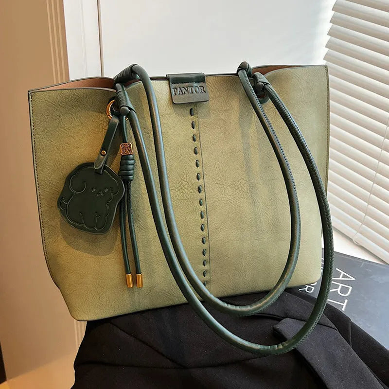 Green urban minimalist PU shoulder bag with stitching detail and double straps on a white background.