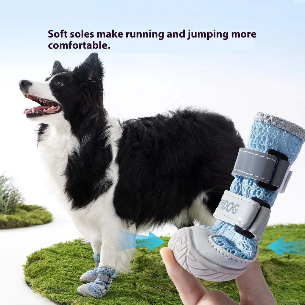 Pair of blue and green breathable mesh dog shoes with thick rubber soles and hook-and-loop straps on a wooden floor.