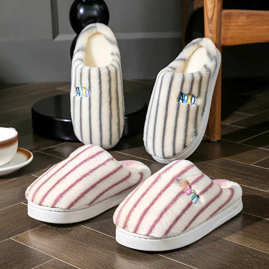 A pair of soft cotton adult slippers with a plastic sole, shown in one of five colour options.