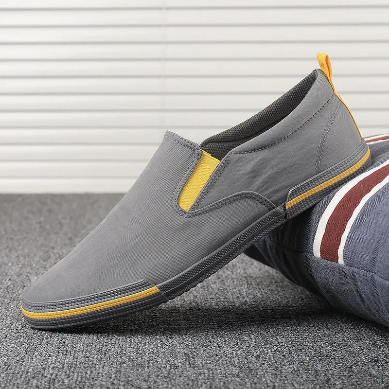 Men's low-top canvas sneakers in grey, black orange, or khaki with a vulcanised rubber sole.