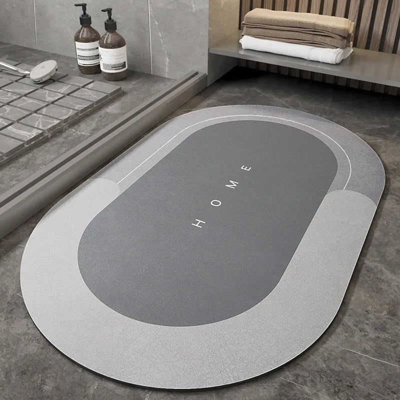 Machine woven bathroom floor mat in blue colour, shown in an oval shape on a tiled floor.