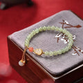 Qingshui jade bracelet with gold-plated details and a fu character on 6mm beads.