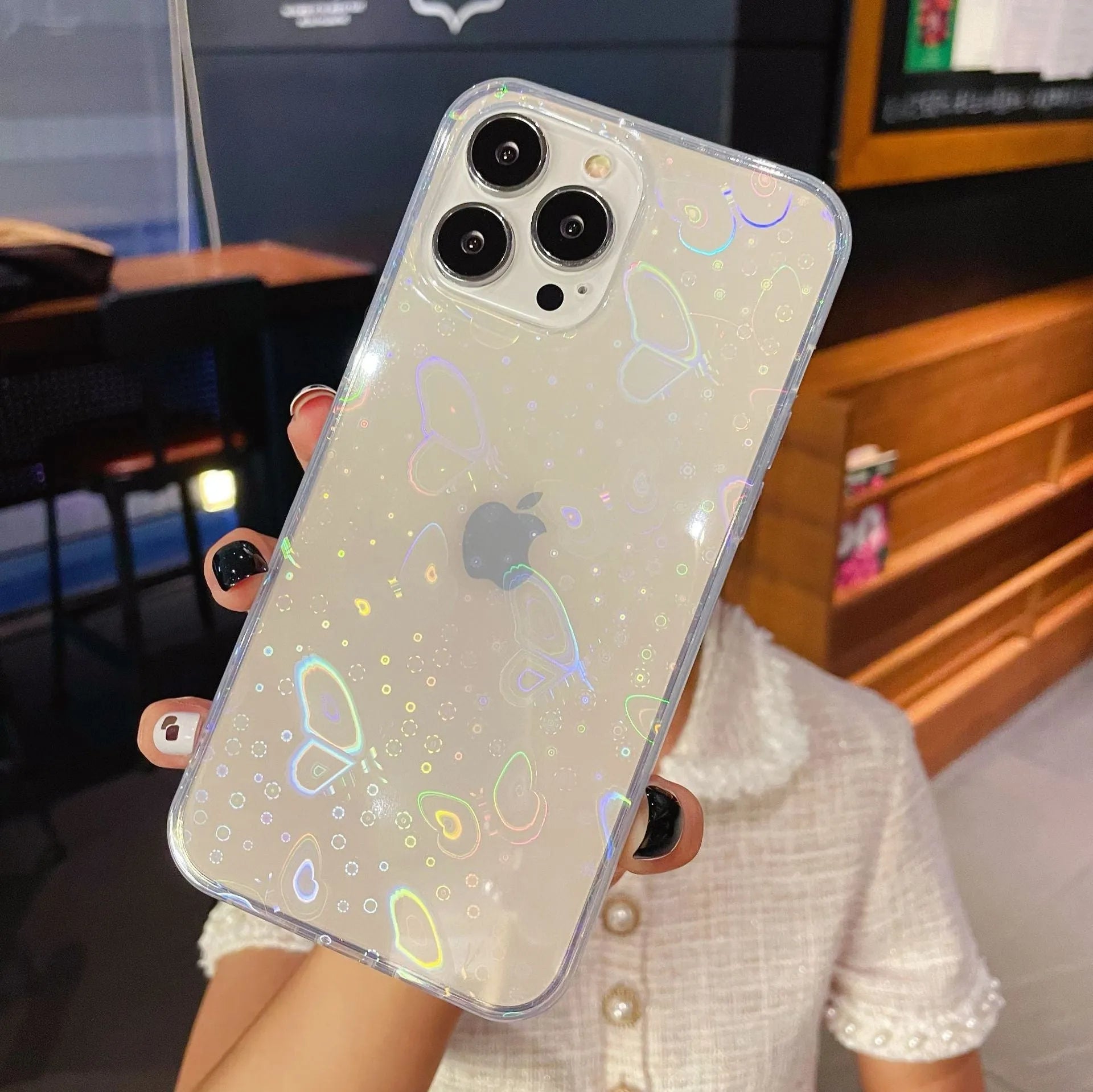Transparent silicone iPhone case with a laser-etched colourful love design, shown next to a butterfly-accented variant.