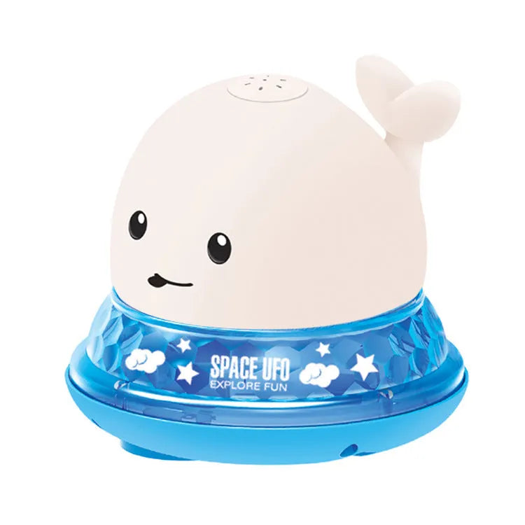Grey and white cartoon whale bath toy spraying water with LED lights illuminated on water surface.