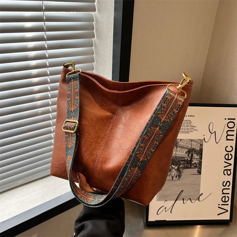 Women's large capacity crossbody bucket bag in PU with nylon lining, available in multiple colours, includes zipper change bag and phone pocket