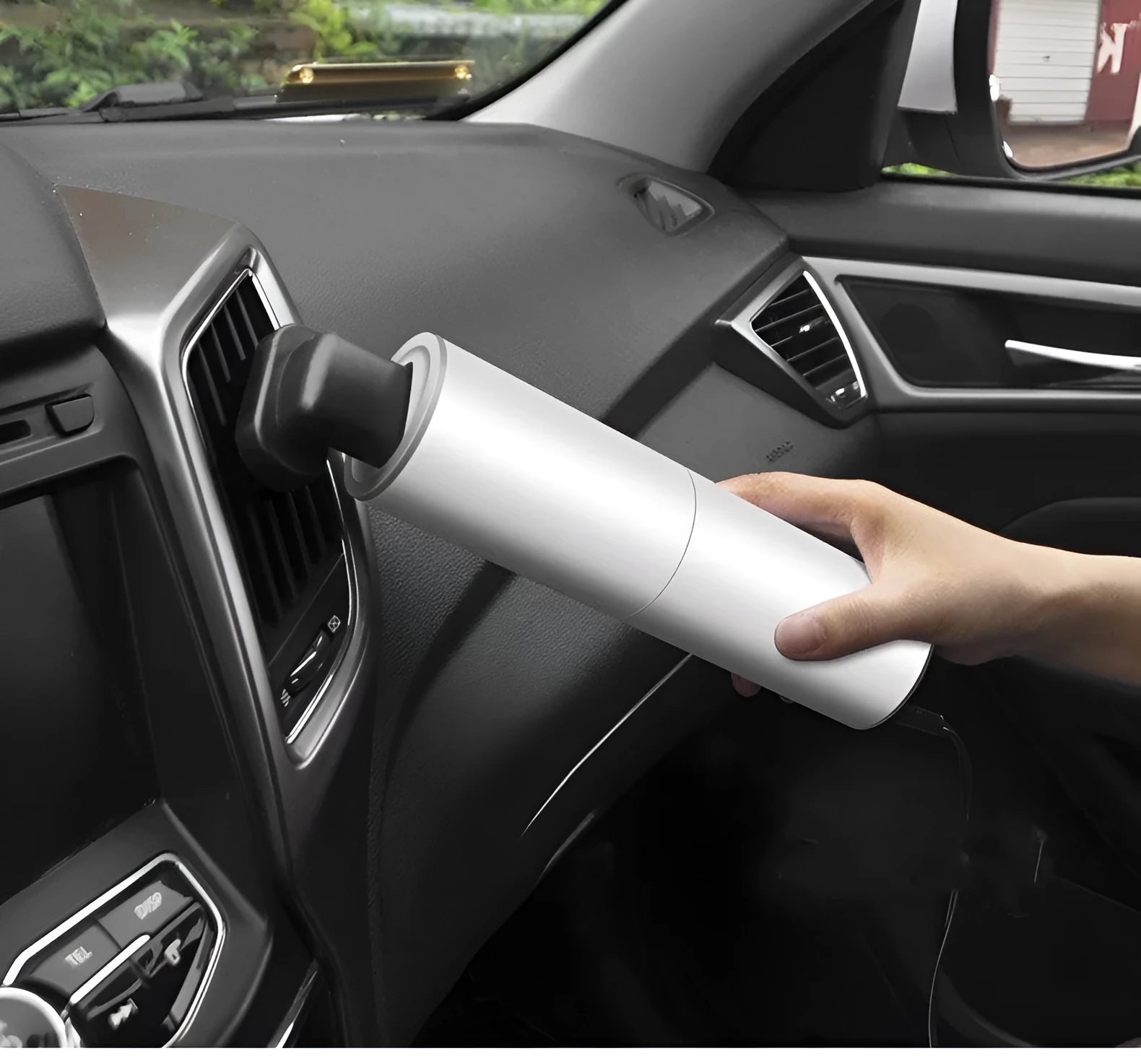 White car mini vacuum cleaner with brush nozzle and long flat nozzle on car seat