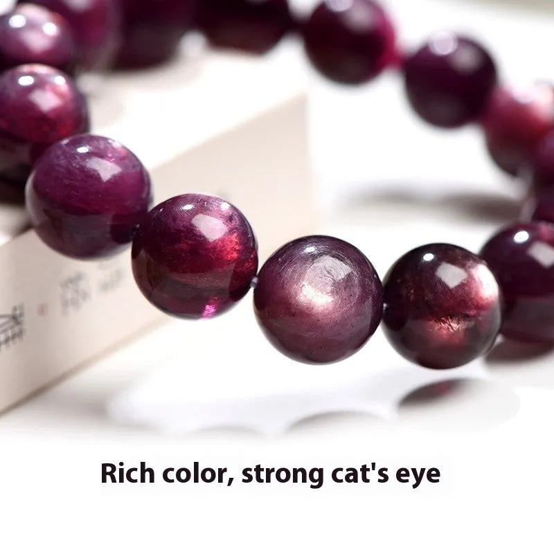 Purple lepidolite crystal round bead bracelet on a wrist, showing polished stones.