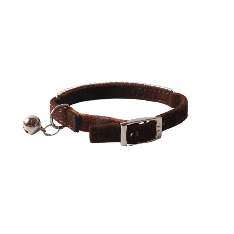Pink flannel cat collar with elastic buckle and silver drill decoration on a grey background.