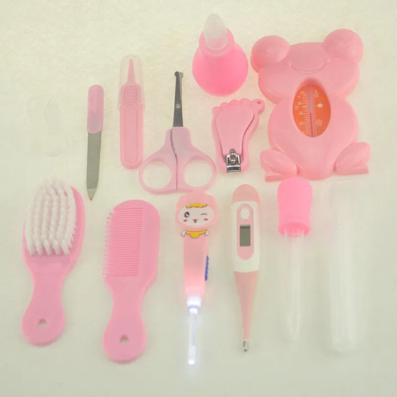 Roadfisher Newborn Baby Care Kit in pink or blue, showing safety scissors, brush, comb, thermometer, and syringe.