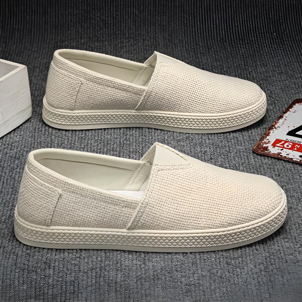 Men's beige linen cloth slip-on shoes with a round toe and shallow mouth on a grey background.