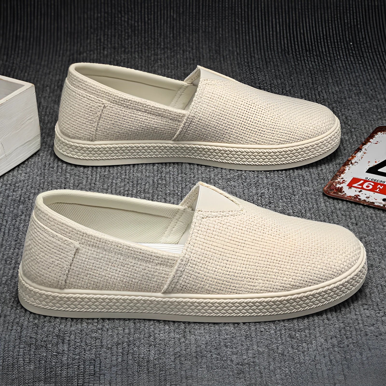 Men's beige linen cloth slip-on shoes with a round toe and shallow mouth on a grey background.
