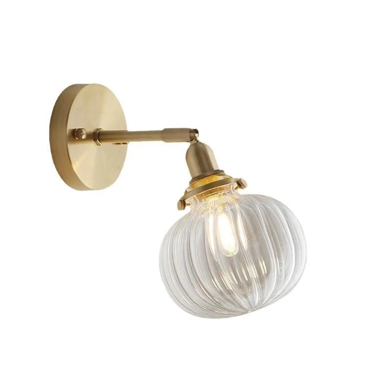 Hand-blown transparent water ripple glass wall lamp mounted on a beige wall, emitting a soft amber glow