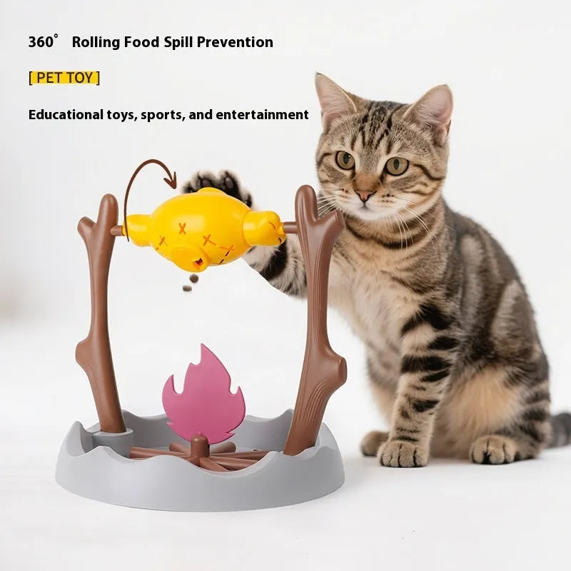 Barbecue-themed tumbling cat food feeder toy with treat dispenser, shown next to dry kibble.