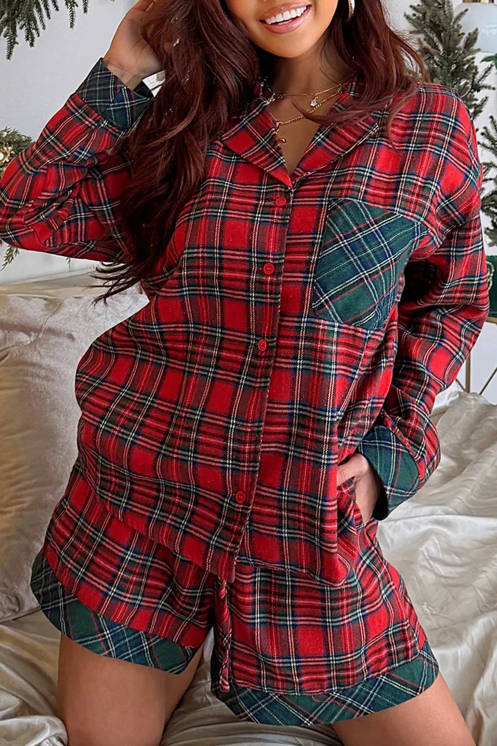 Red plaid Christmas pyjama set with contrast patch on shirt and matching shorts, laid flat.