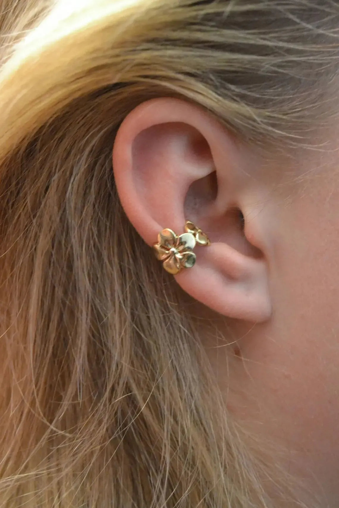 Gold coloured starfish and conch drop earrings on a white background.