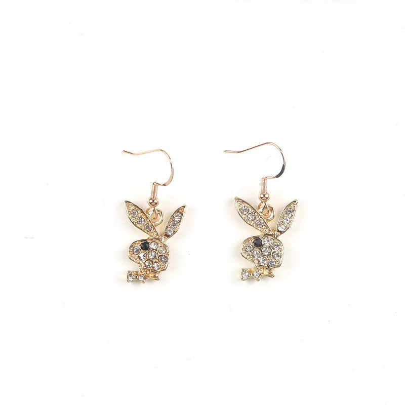 Close-up of a pair of small silver rabbit stud earrings with a sparkling rhinestone set in the centre on a white background.