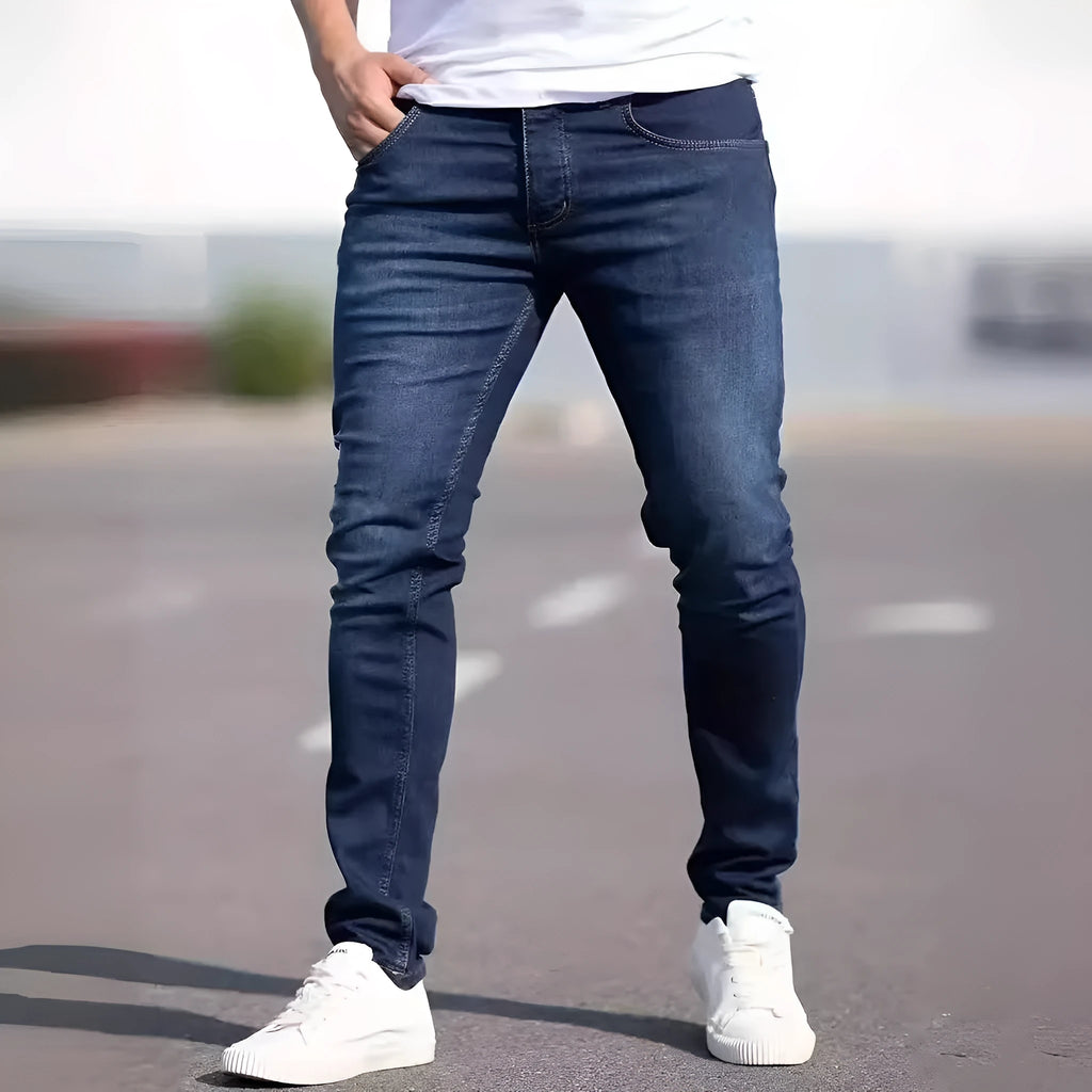 Man wearing dark blue slim-fit skinny jeans with a medium-elastic waist and zipper fly.