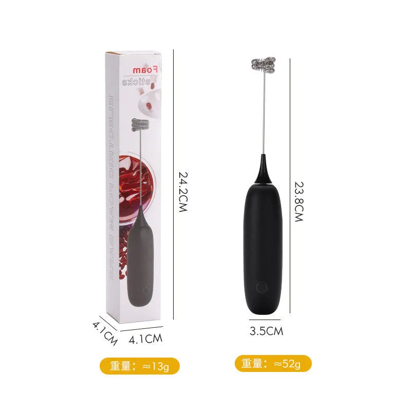 Black and white hand-held electric milk frother and blender on a kitchen counter.