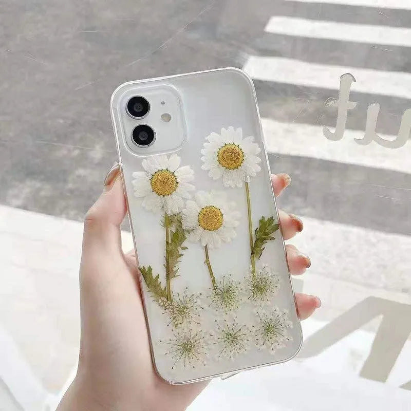 White iPhone case with a raised epoxy daisy floral design on the back.