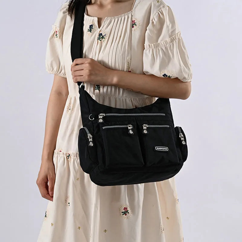 Women's waterproof nylon crossbody shoulder bag in black with multiple pockets and telescopic handle