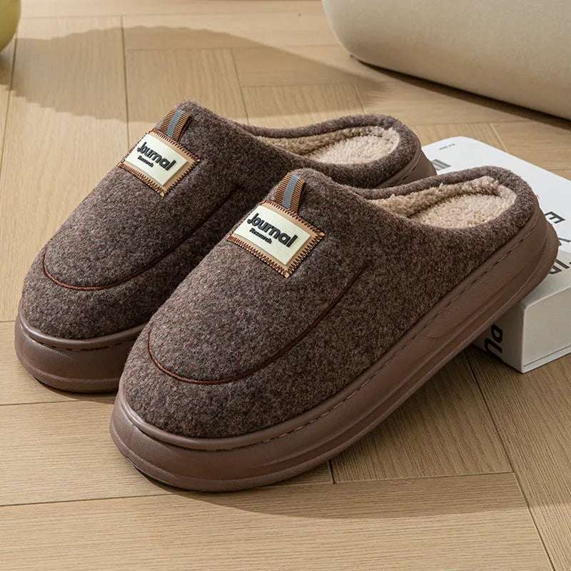 Men's grey suede slippers with a thickened sole shown on a wooden floor.