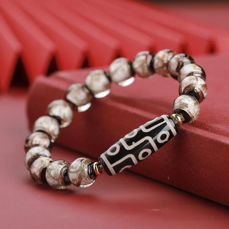 Close-up of a handmade Chinese-style bracelet with coloured glaze lucky beads on a snake theme.
